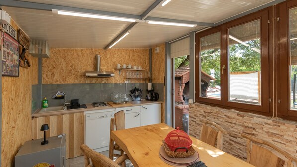 Una cocina compacta con armarios de madera, estufa integrada y un comedor con mesa y sillas.