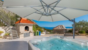 A hot tub area with a stone structure and a view of the sea. - Villa Ana - Makarska by Villas Guide (Makarska)