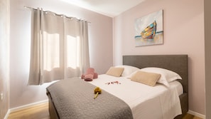 A bedroom with a bed, curtains, a painting, and a bouquet of flowers. - Holiday home Erika by Villas Guide (Vela Luka)