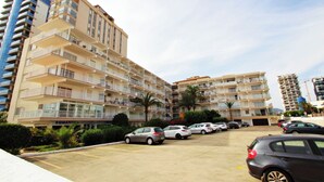 A multi-story hotel with balconies, a parking lot, and a visible restaurant named 'Romantic'.