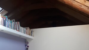A bedroom with a bed, a bookshelf, and a wall with a string of decorative balls. - Organic and eco-friendly B&B du Besset (Yssingeaux)