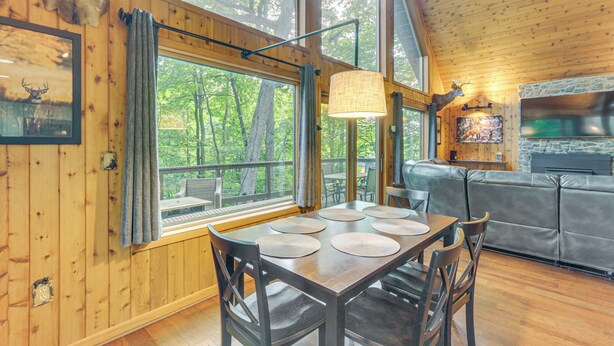 A wooden cabin interior with a dining table, chairs, a sofa, and a stone fireplace. - Serene Mountain Home: 11 Mi to Gettysburg (Fairfield)