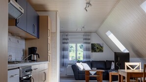 A modern kitchen with a built-in oven and a dining area with a wooden table and chairs. - Vacation Rental in Winningen with a View of the Moselle (Winningen)