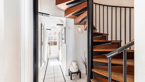 A modern staircase with wooden steps and black railings, leading to an upper floor.