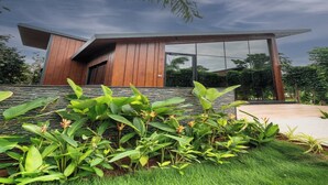 Una casa moderna con un amplio ventanal y fachada de madera.