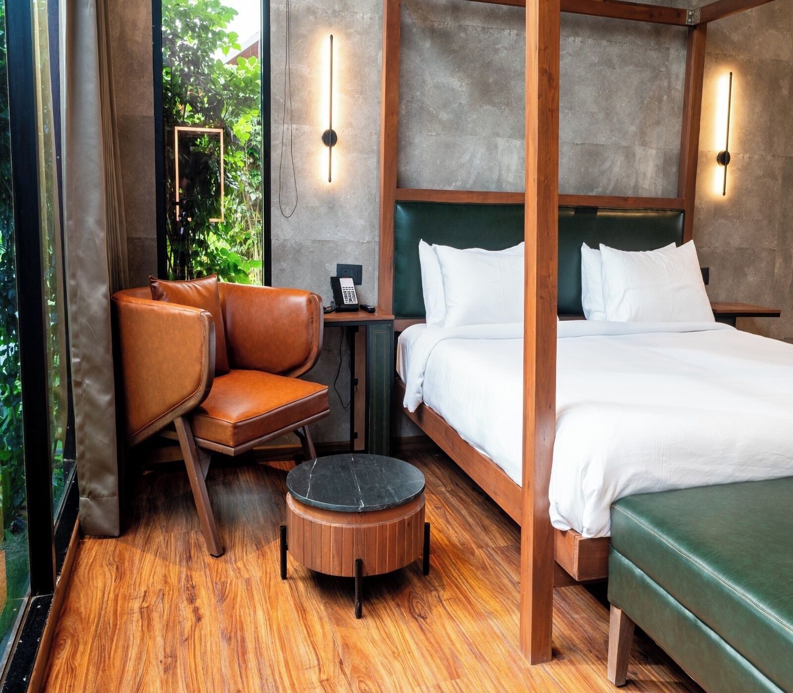 A room with a bed, a chair, a small table, and a bench.