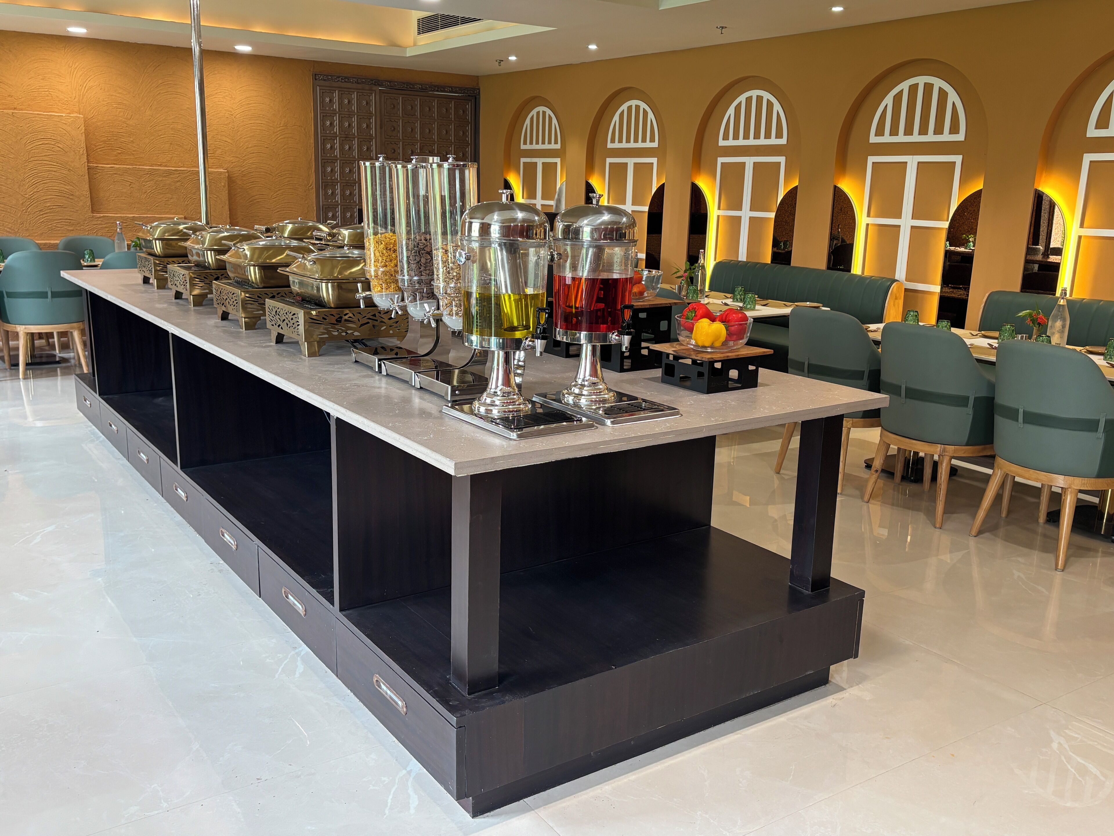 A buffet setup with various food containers and a beverage dispenser.
