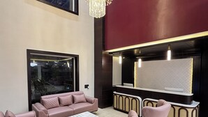 A modern living room with a large window, plush seating, a flat-screen TV, and decorative lighting. - Anandi Bhawan by Pandora, Vrindavan (Mathura)