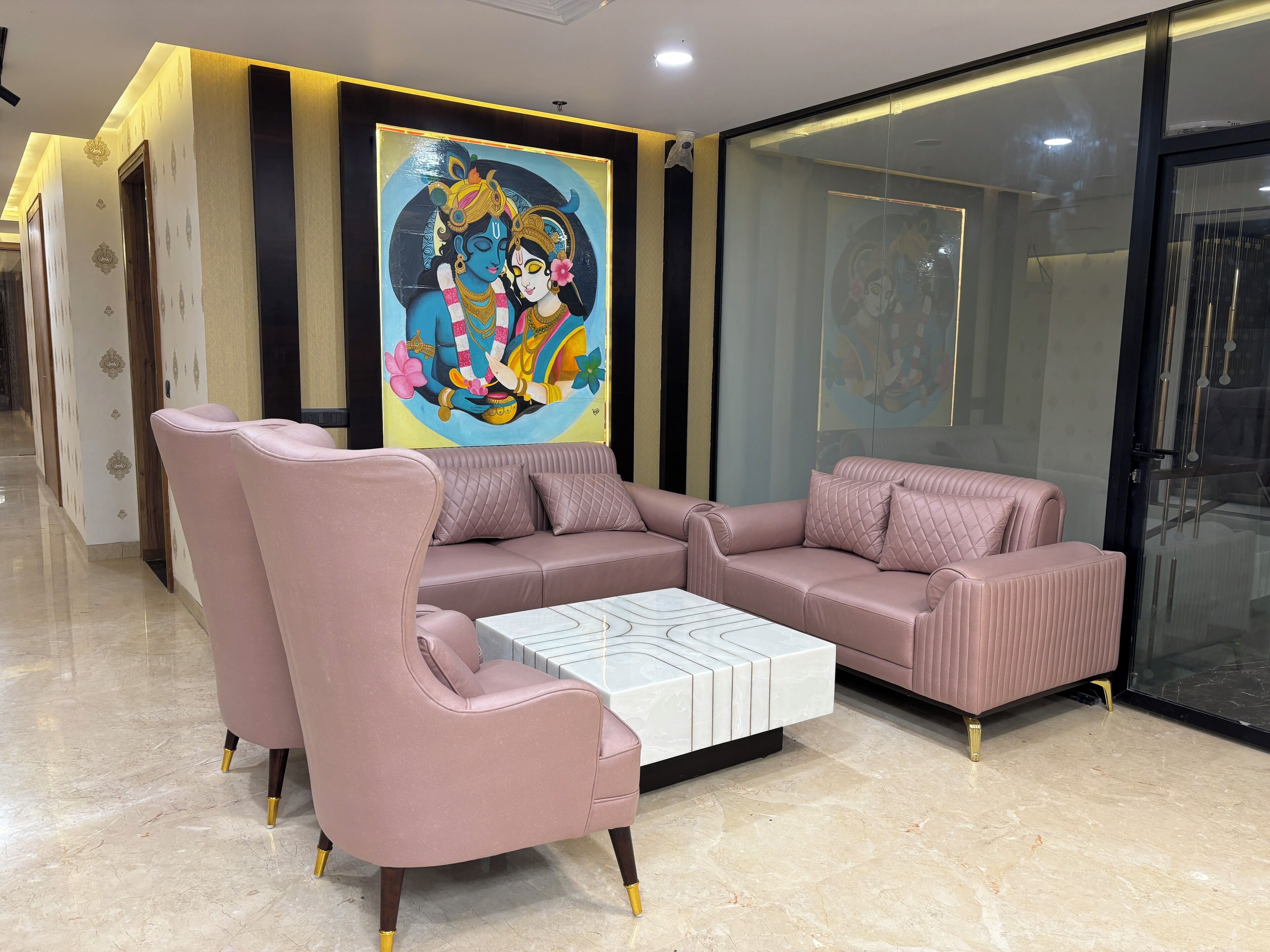 A modern living room with a sofa set, a coffee table, and a large wall painting.