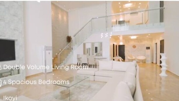 A modern living room with a double volume layout, four spacious bedrooms, and a staircase leading to an upper level. - Luxurious 4-Bedroom Serviced Penthouse – The Pearls, Ikoyi (Lagos)