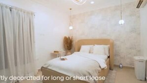 A minimally decorated bedroom with a bed, curtains, and a nightstand. - Luxurious 4-Bedroom Serviced Penthouse – The Pearls, Ikoyi (Lagos)