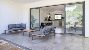 Een modern interieur met een eethoek, keuken en een glazen deur naar een terras.