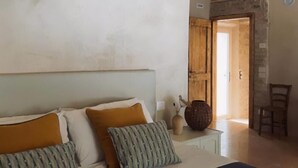 A bedroom with a bed, pillows, a nightstand, a vase, and a chair. - Il Mulino dei Veraghi (Molina)