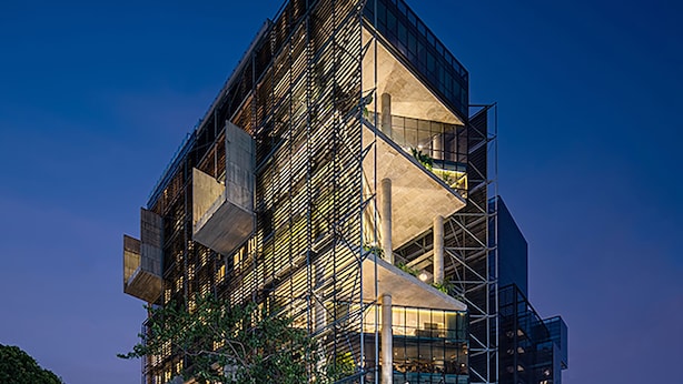 A modern building with a unique angular design, featuring multiple levels and balconies.