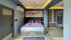 Una habitación de hotel moderna con una cama grande, un ventilador de techo y un adorno mural.