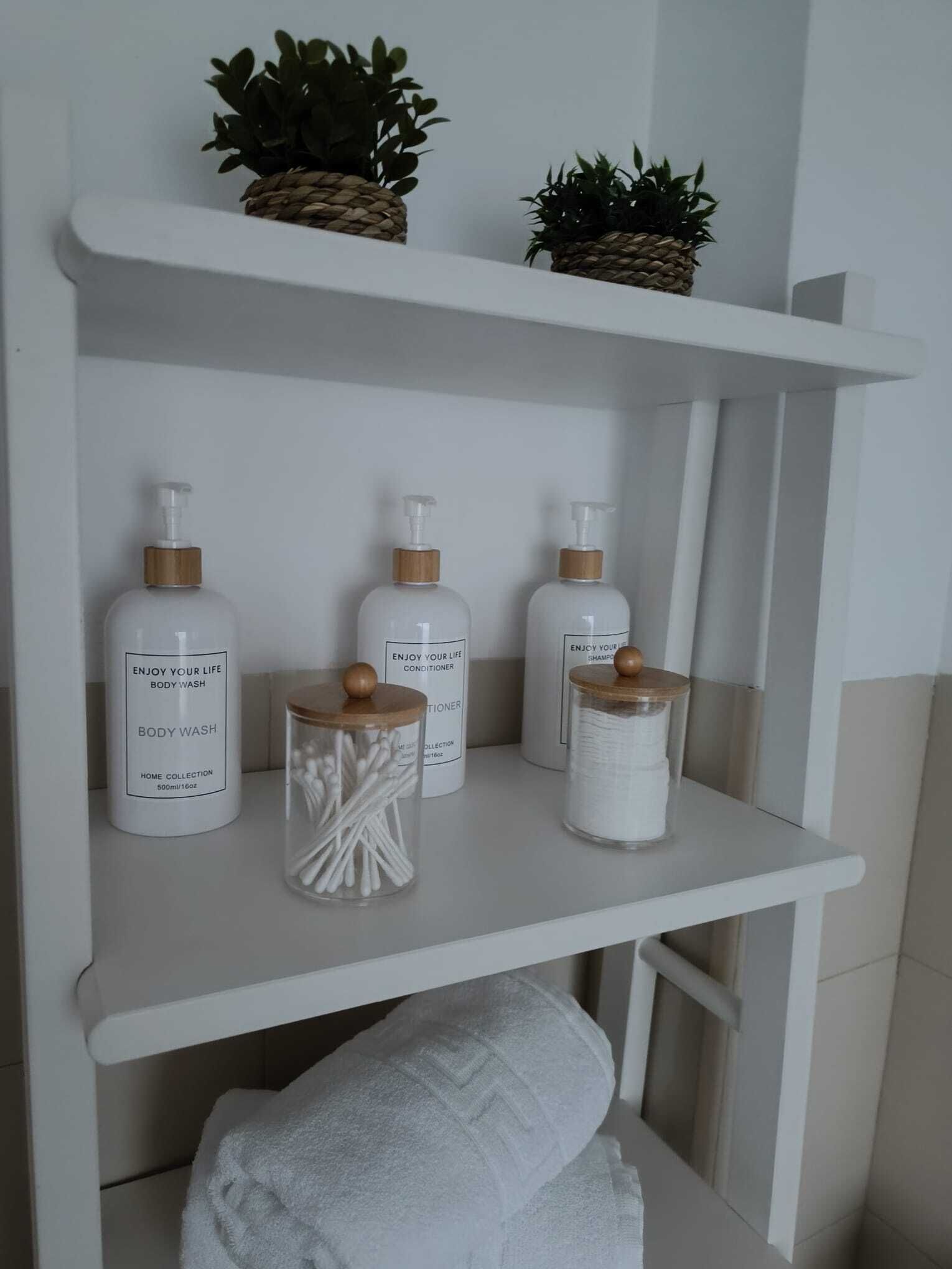 A bathroom shelf with toiletries including body wash, conditioner, and shampoo.