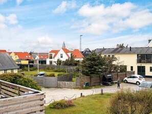 A residential area with houses, a wooden fence, and a person walking. - 5 Star Holiday Home in Lokken (Lokken)