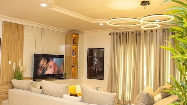 A modern living room with a sofa, TV, and decorative items. - Smart 3-Bedroom Apartments – A Home Away From Home (Lagos)