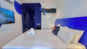Une chambre d’hôtel moderne dotée d’un grand lit, d’un téléviseur à écran plat et offrant une vue sur la salle de bain.