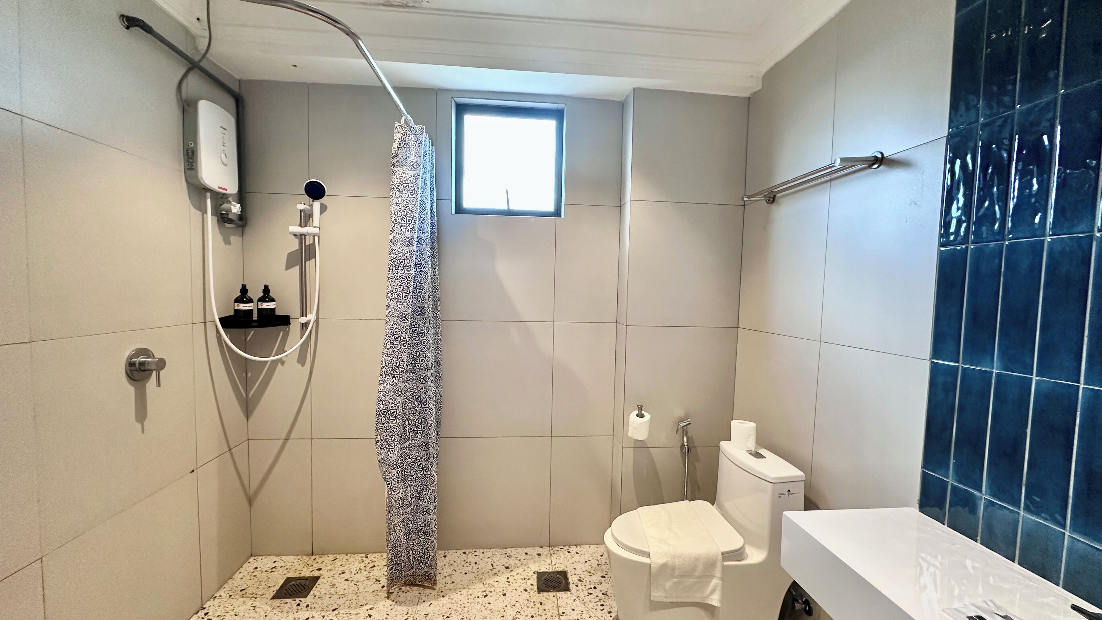 A small bathroom with a shower, toilet, and sink.