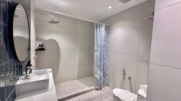 Un baño moderno con ducha, inodoro y lavamanos.