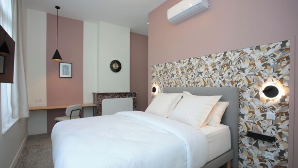Quarto com cama, escrivaninha e cadeira.