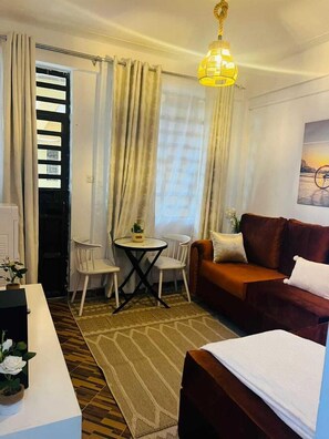 Family Apartment, City View | Living area | 32-inch Smart TV with digital channels