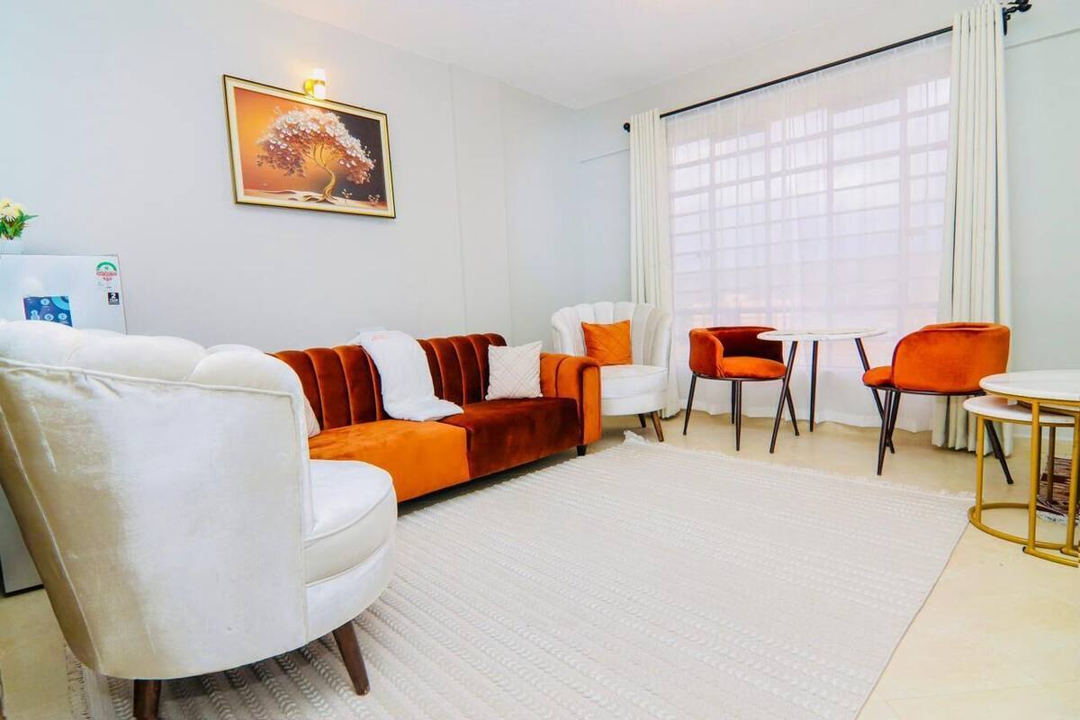 A modern living room with a sofa, chairs, and a small table.