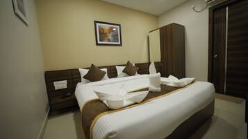 Habitación de hotel con una cama bien hecha, un armario, un cuadro en la pared y una mesita de noche con un teléfono.