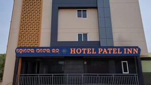 Un bâtiment moderne sur lequel on peut lire l’inscription : « HÔTEL PATEL INN ».