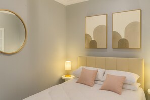 A hotel room with a bed, a nightstand, a lamp, and two wall-mounted paintings. - Lux Urban Terra (Darlinghurst)
