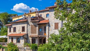 A stone building with multiple balconies and a tiled roof.