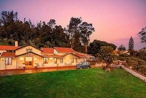 A two-story house with a red-tiled roof, a front porch, and a car parked in the driveway. - Rosewood by Nature resorts & stays  (Ooty)