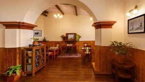 Una habitación acogedora con suelo de madera, chimenea, estantería y una mesa de comedor.