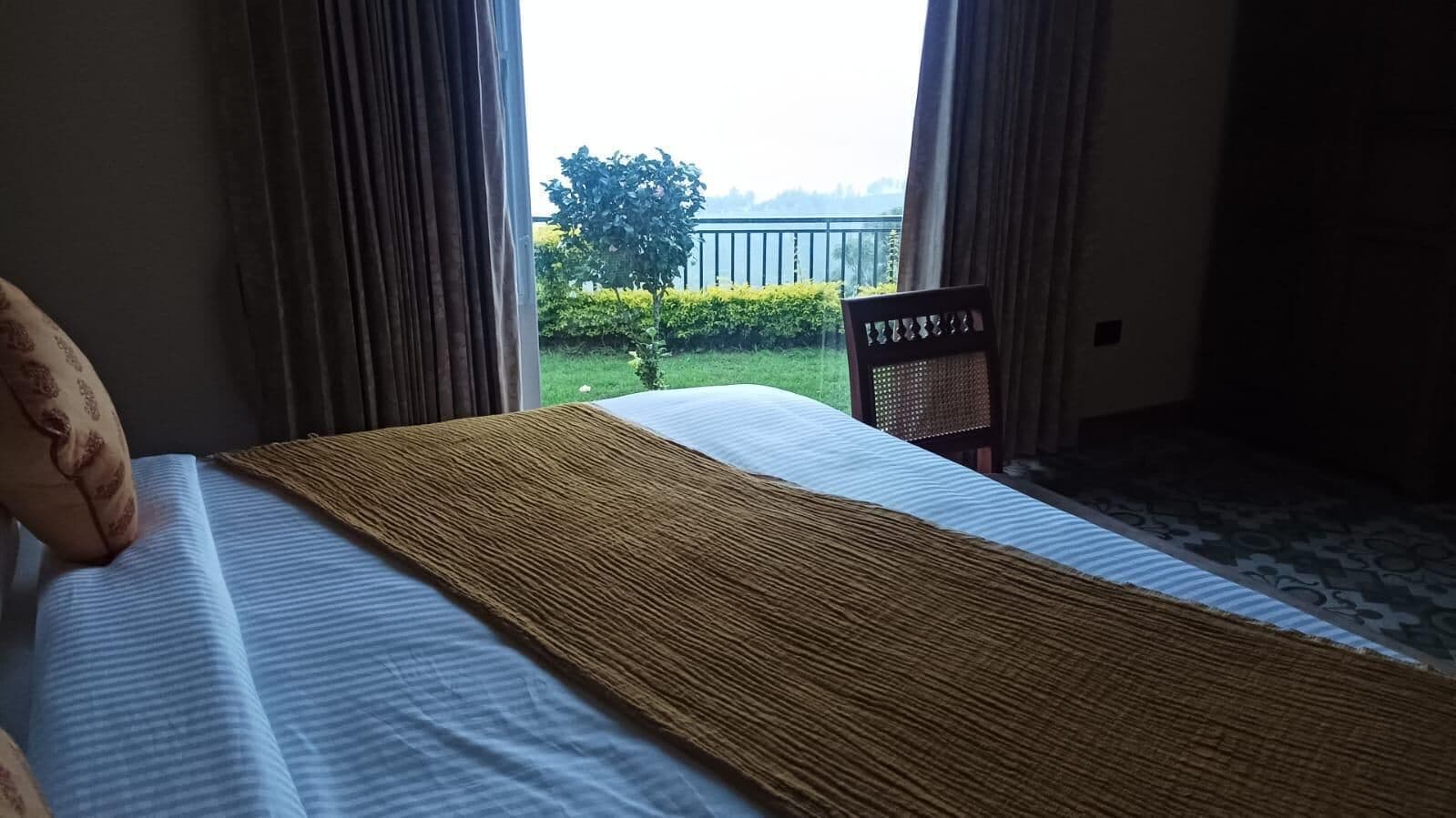 Een hotelkamer met een bed, een balkonzicht en een stoel.