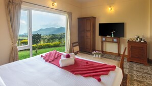 A hotel room with a large bed, a TV, a wooden wardrobe, and a view of the outdoors. - Teanest Nightingale - Nature Resorts (Kotagiri)