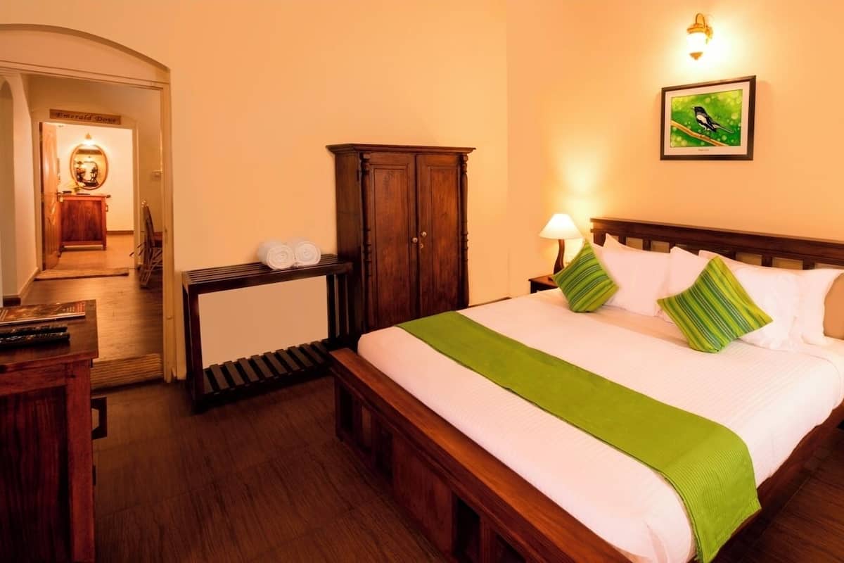 Een netjes ingerichte hotelkamer met een bed, nachtkastjes, een kledingkast en een spiegel.
