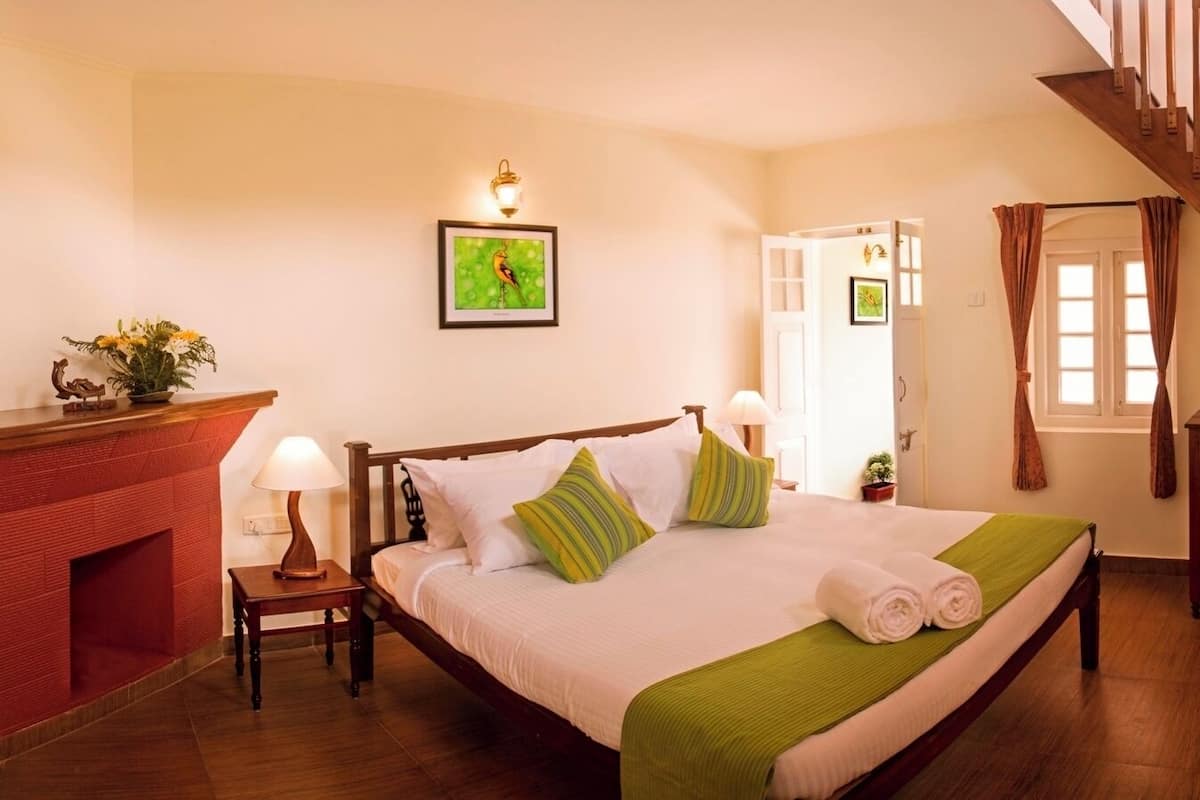 Een slaapkamer met een houten bed, een open haard, een televisie en een trap.