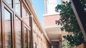 A narrow brick corridor with wooden paneling and large windows on one side. - Sabah Hotel (Baku)