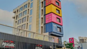 A multi-story building with a modern architectural design, featuring a series of stacked shipping containers on its facade. - Hotel The Container (Kolhapur)