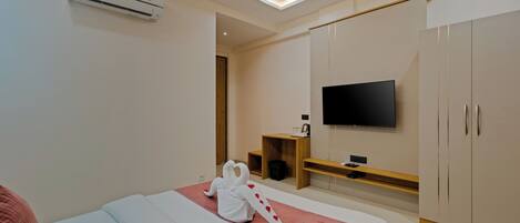 Camera d'albergo moderna con un letto, una televisione a schermo piatto montata a parete, una ventola a soffitto e un armadio.