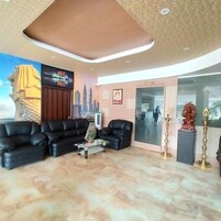 A modern lobby with a black leather sofa, a glass coffee table, and a cityscape mural.