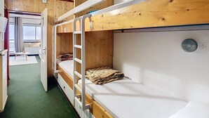 A bunk bed room with a wooden ceiling, a small table, and a window with curtains. - Apartment Residence at the foot of the slopes "Zen Altitude" 6 people (Eaux-Bonnes)