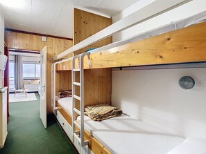 A bunk bed room with a wooden ceiling, a small table, and a window with curtains. - Apartment Residence at the foot of the slopes "Zen Altitude" 6 people (Eaux-Bonnes)