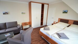 A bedroom with a bed, a sofa, a desk, and a wardrobe. - Zum Brandenburger Tor 10 (Damme, Dümmer)