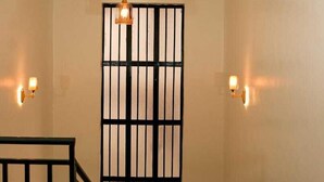 A staircase with a black railing leading to a room with a large window and a decorative ceiling. - Lux Suites Advent Homes Naivasha (Naivasha)
