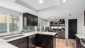 A modern kitchen with dark cabinetry, a white countertop, and a built-in oven. - NEW|The Bungalow @ Old Town|Al-Fresco Living|Pool (Scottsdale)