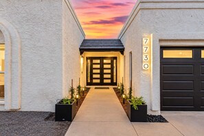 A modern house with a driveway leading to a dark garage door.