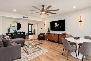 A modern living room with a sofa, coffee table, and dining area.