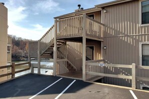A building with a wooden deck and a staircase leading to an upper level.